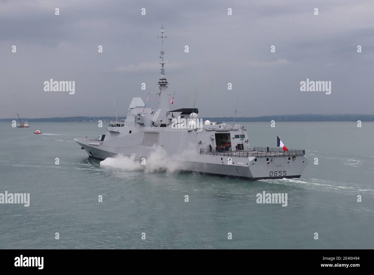 The French multi-purpose frigate FS BRETAGNE heads into the Solent under a leaden sky. The ship was departing after a 5 day visit to the Naval Base Stock Photo