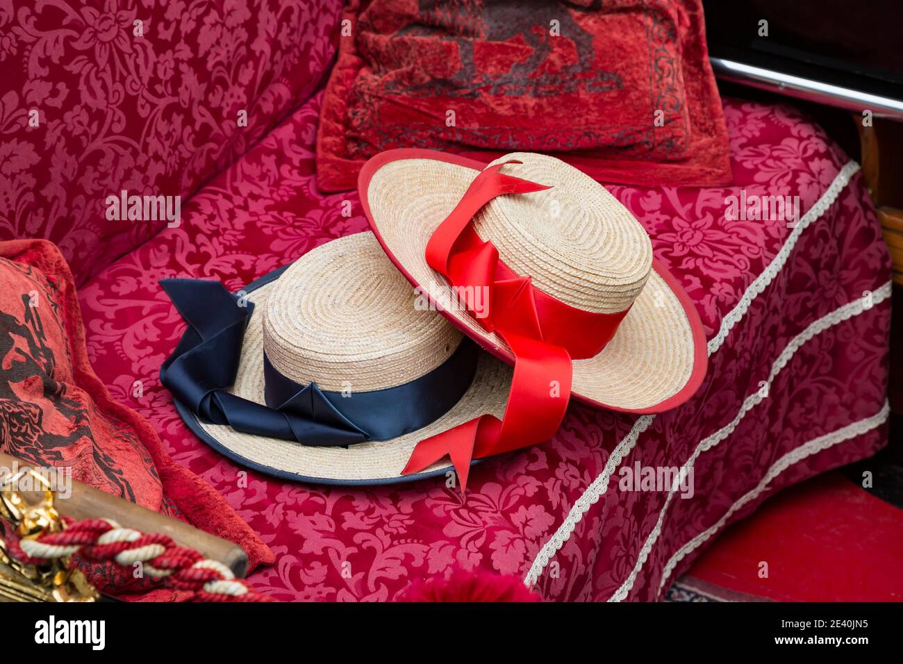 Venetian gondolier's red and blue hats on the sitting bench of a gondola, Venice, Italy Stock Photo