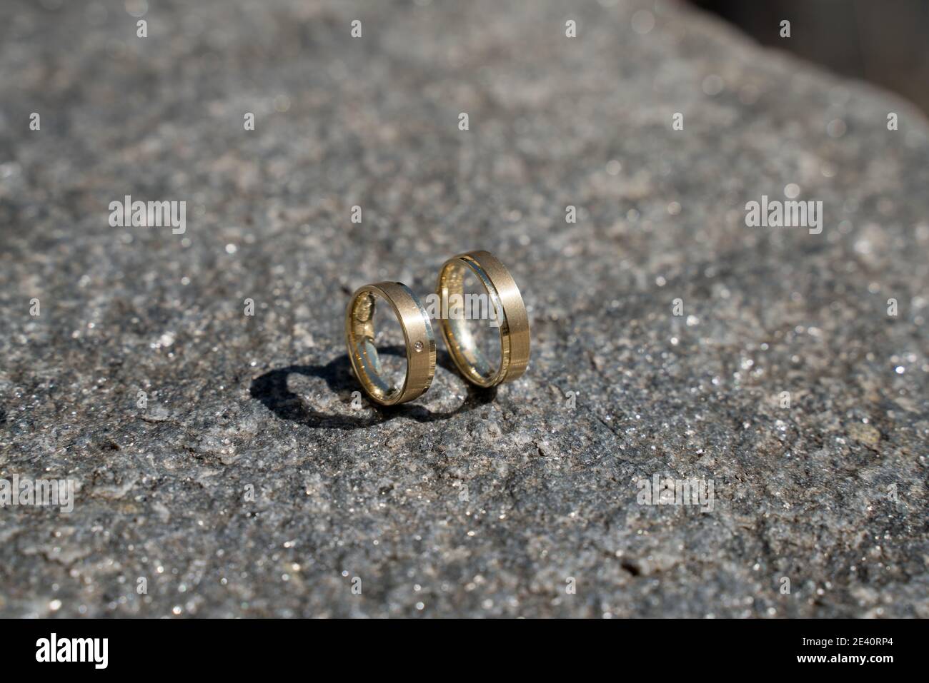Zwei Trauringe auf Holz und Stein Oberfläche, wedding rings Stock Photo