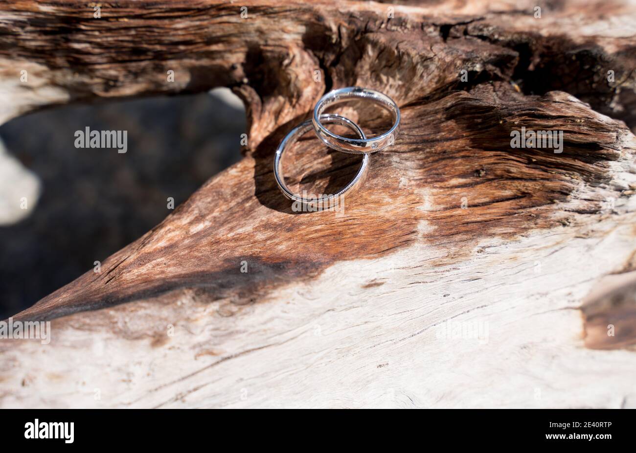 Zwei Trauringe auf Holz und Stein Oberfläche, wedding rings Stock Photo