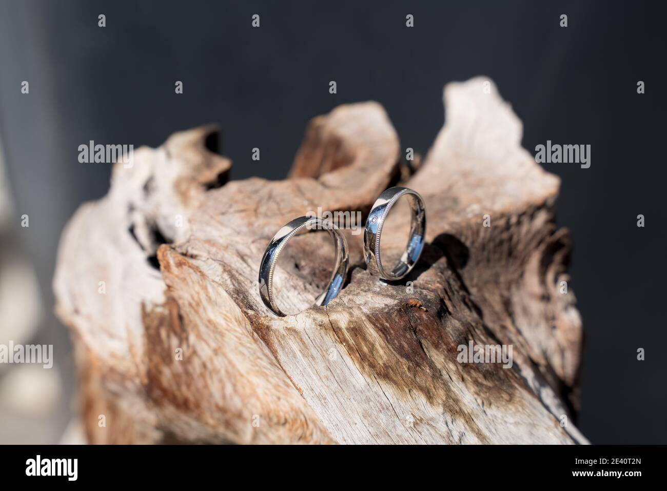 Zwei Trauringe auf Holz und Stein Oberfläche, wedding rings Stock Photo