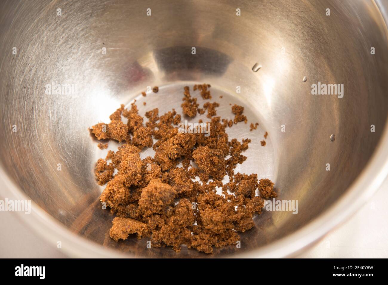 A pile of brown sugar in steel bowl. Close-up. Stock Photo
