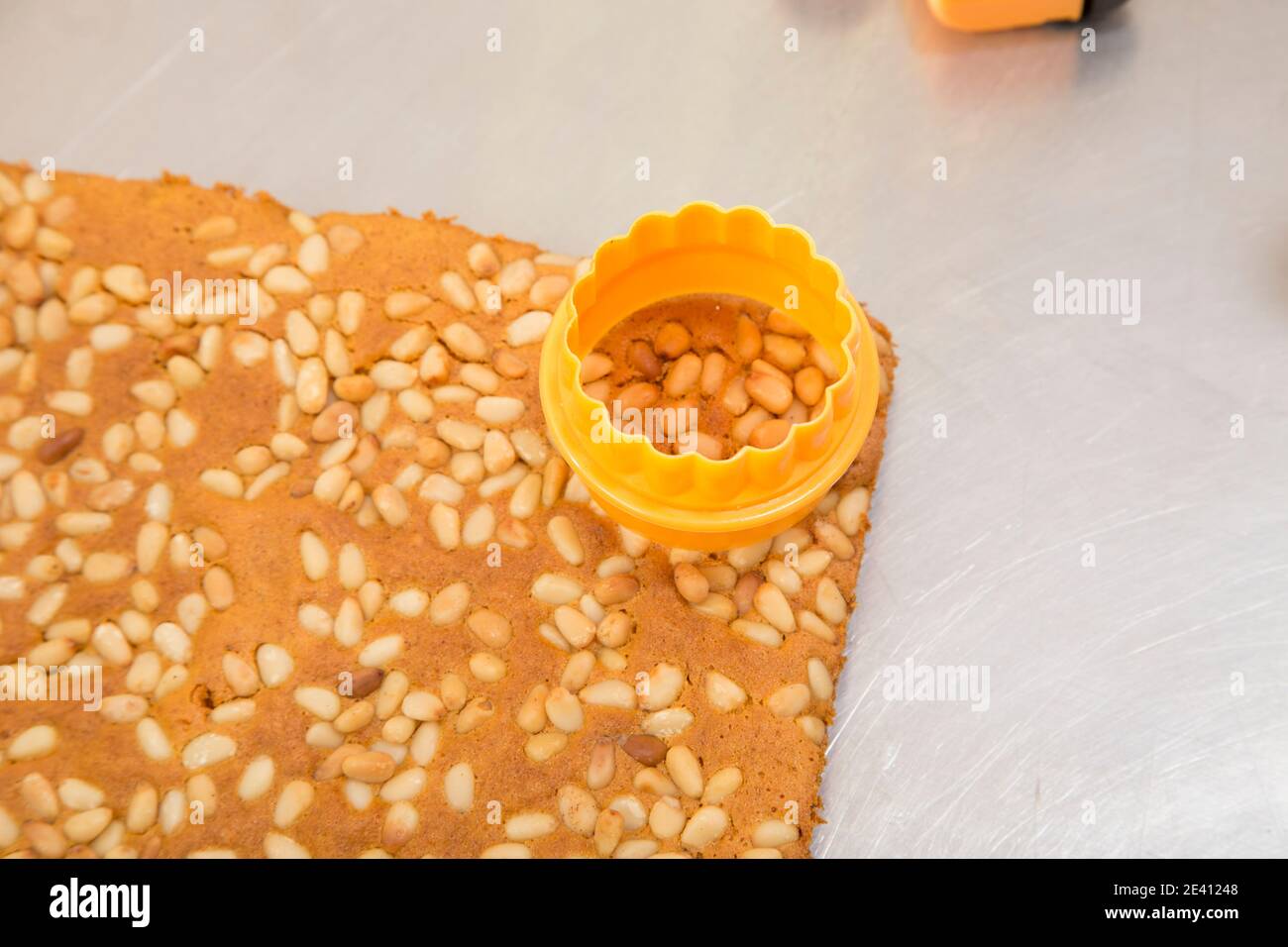 Ready carrot sponge cake with pine nuts. It is located on a metal surface. Close-up. Stock Photo