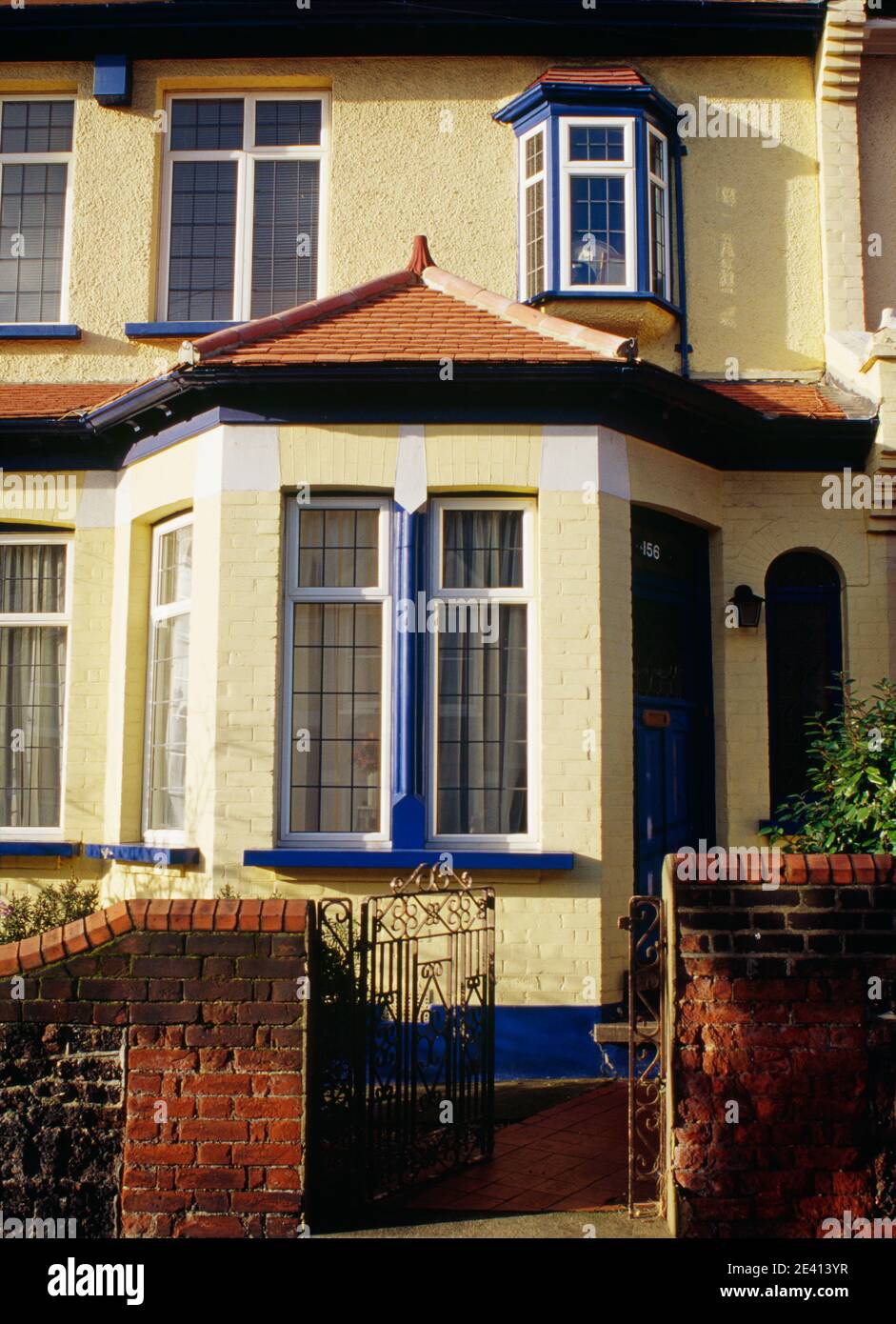 Bay window 1900s housing painted yellow & blue Stock Photo - Alamy