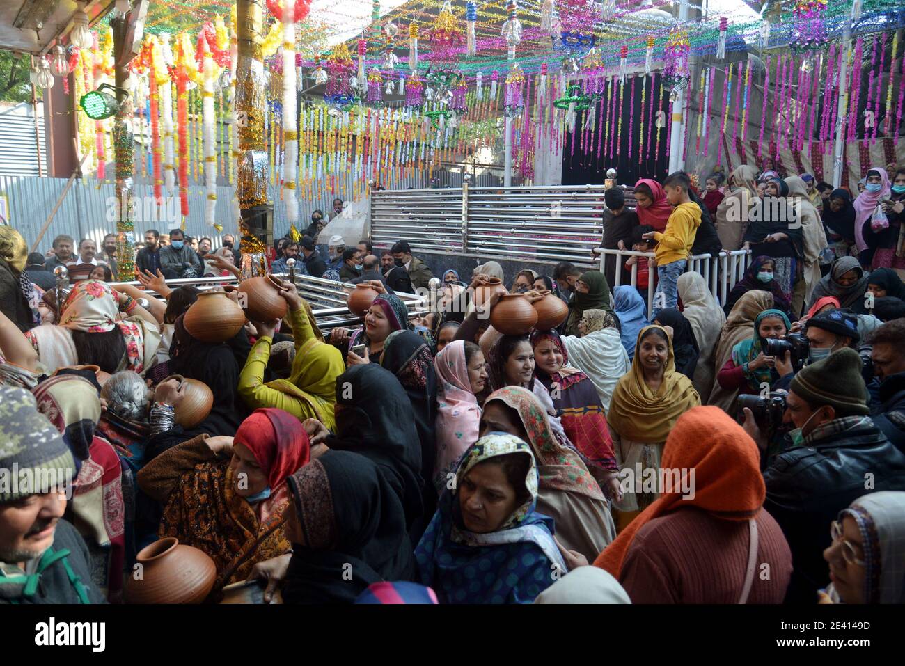 Lahore, Pakistan. 20th Jan, 2021. Pakistani women devotees bringing water for ablution of the graves at the shrine of the mausoleum of Ruqayyah Bint Ali known as Bibi Pak Daman in Lahore, Pakistan on Jan. 20, 2021. Women devotees participate rituals during 994th three days annual religious ritual washing ceremony on the eve of Urs celebrations. Bibi Pak Daman is the mausoleum of Ruqayyah bint Ali located in Lahore. Legend has it that it holds the graves of six ladies from Muhammad's household (Ahl Al-Bayt). (Photo by Rana Sajid Hussain/Pacific Press/Sipa USA) Credit: Sipa USA/Alamy Live News Stock Photo