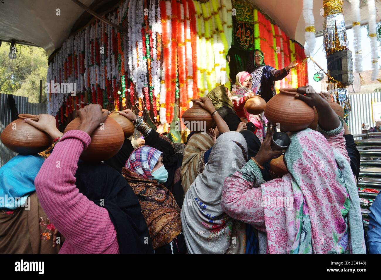 Lahore, Pakistan. 20th Jan, 2021. Pakistani women devotees bringing water for ablution of the graves at the shrine of the mausoleum of Ruqayyah Bint Ali known as Bibi Pak Daman in Lahore, Pakistan on Jan. 20, 2021. Women devotees participate rituals during 994th three days annual religious ritual washing ceremony on the eve of Urs celebrations. Bibi Pak Daman is the mausoleum of Ruqayyah bint Ali located in Lahore. Legend has it that it holds the graves of six ladies from Muhammad's household (Ahl Al-Bayt). (Photo by Rana Sajid Hussain/Pacific Press/Sipa USA) Credit: Sipa USA/Alamy Live News Stock Photo
