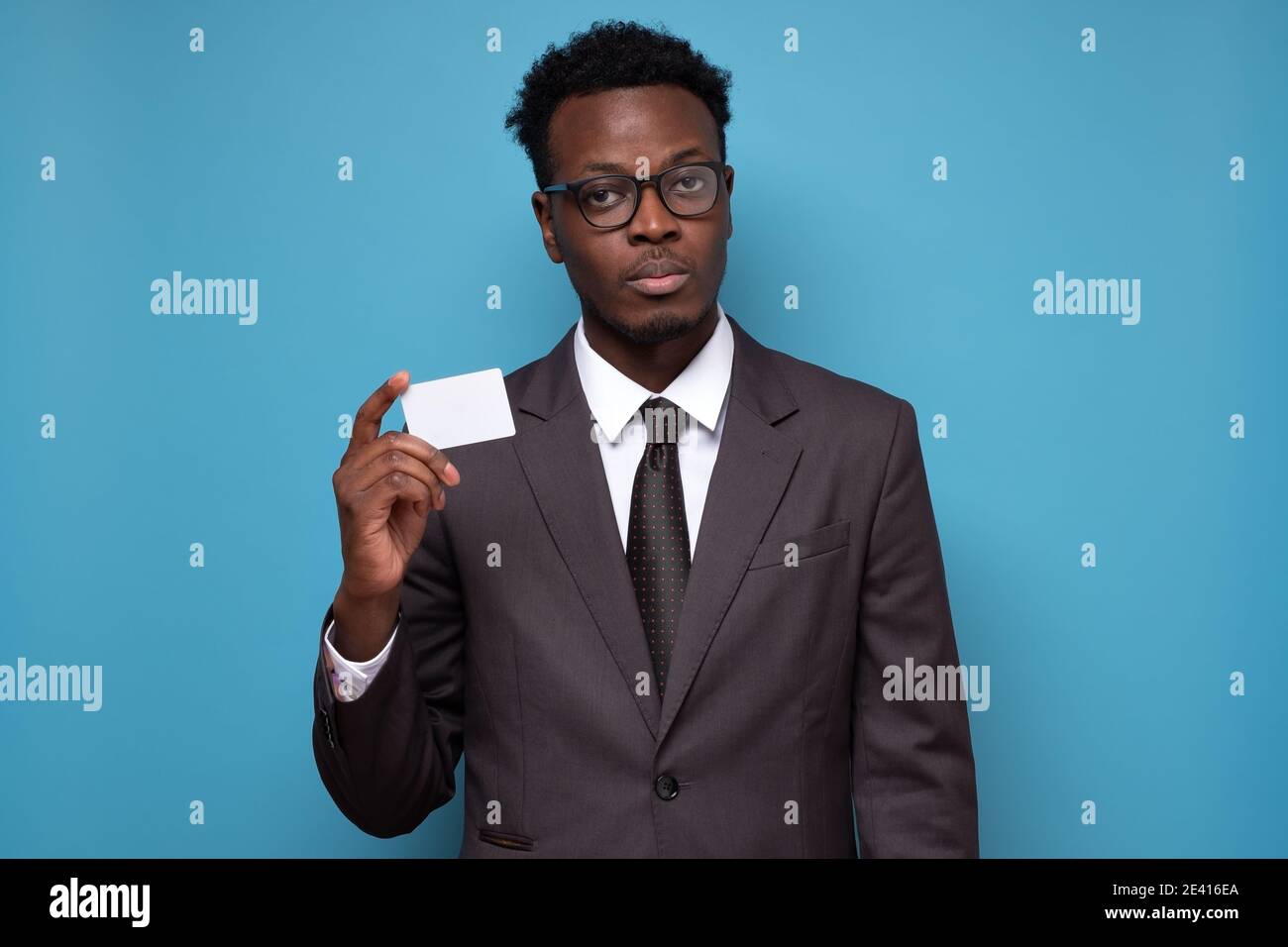 Young serious african businessman holding Credit Card Stock Photo - Alamy