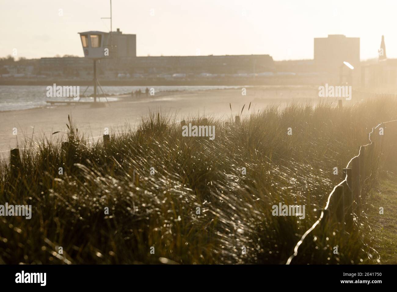 Kiel, Germany. 21 Jan 2021. People walking on the beach against the light in stormy weather. Credit: Frank Molter/Alamy Live News Stock Photo