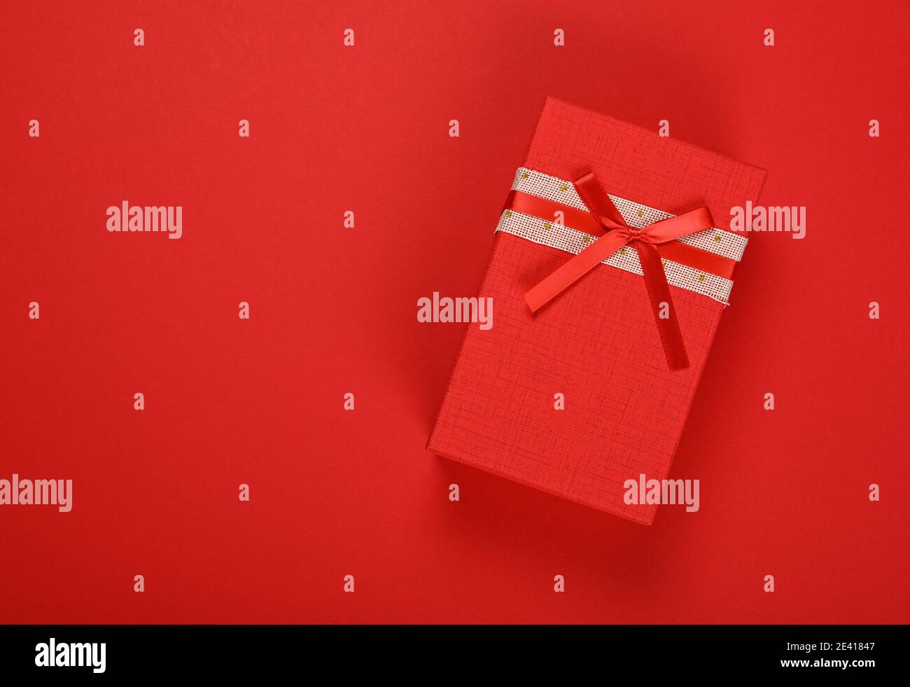Valentine template of closed vivid red gift box with ribbon chiffon bow over  red wrapping paper background, close up flat lay, elevated top view, dire  Stock Photo - Alamy