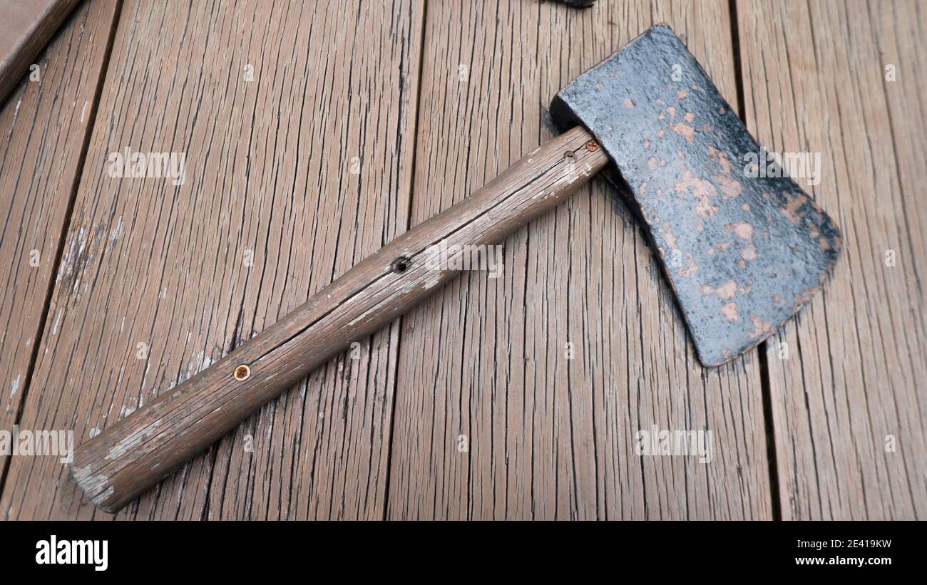 Children Derivation dispatch An old axe with a wooden handle on the top of the wooden table Stock Photo  - Alamy