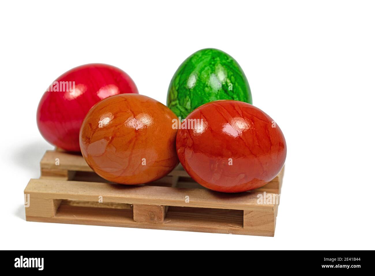Colorful Easter eggs on a wooden pallet against a white background Stock Photo