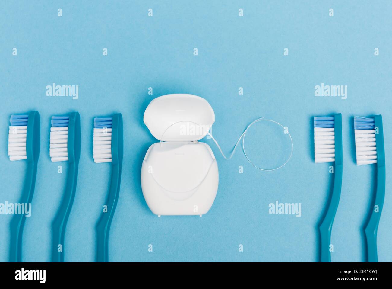 Top view of toothbrushes and dental floss on blue background Stock ...