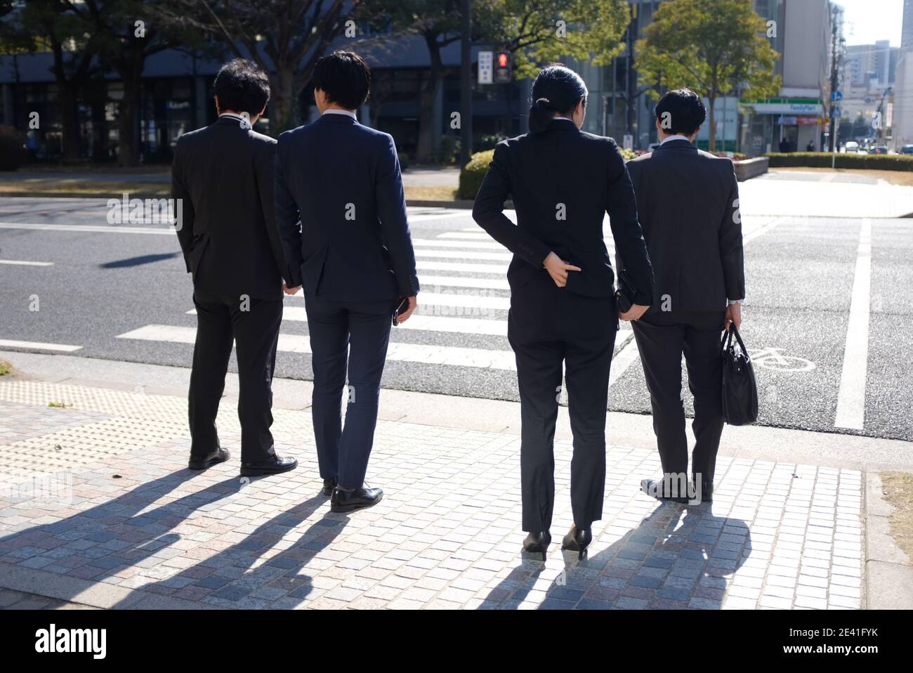 HIROSHIMA, JAPAN Japanese business men and woman crossing the road in