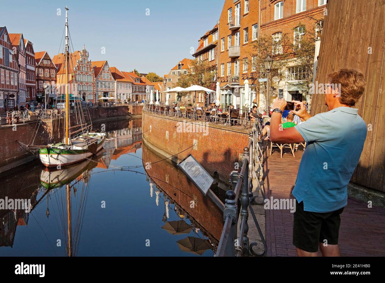 Stade old town, man taking photo of Hanse port with sailing ship Willi, Germany, Lower Saxony, Stade Stock Photo