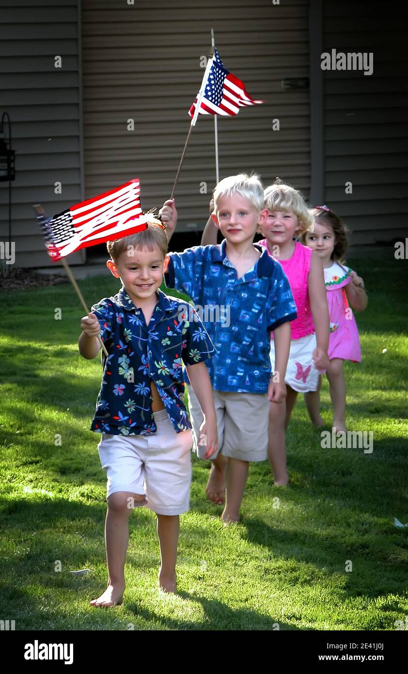 A parade of children marching holding flags over their head march in a line to celebrate thee