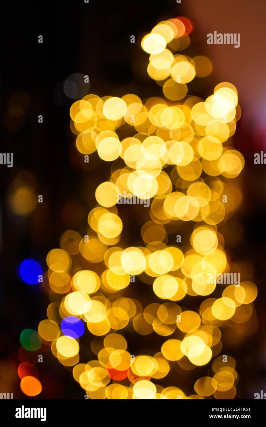Vertical blurred shot of the decorative lights on a Christmas tree ...