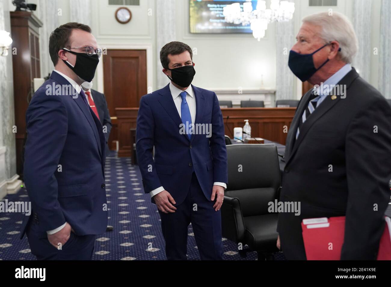 Pete Buttigieg, U.S. secretary of transportation nominee for U.S. President Joe Biden, center, wears a protective mask while talking to United States Senator Roger Wicker (Republican of Mississippi), Chairman, US Senate Committee on Commerce, Science, & Transportation, right, during a confirmation hearing in Washington, DC, U.S., on Thursday, Jan. 21, 2021. Buttigieg, is pledging to carry out the administration's ambitious agenda to rebuild the nation's infrastructure, calling it a 'generational opportunity' to create new jobs, fight economic inequality and stem climate change. Credit: Stefa Stock Photo