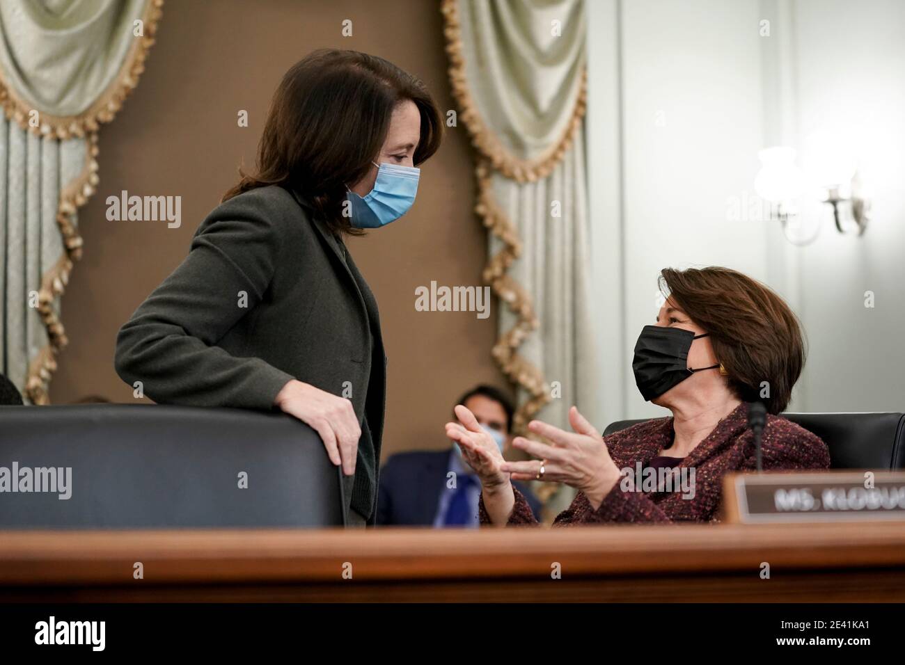 United States Senator Maria Cantwell (Democrat of Oregon), Ranking Member, US Senate Committee on Commerce, Science, & Transportation, left, and US Senator Amy Klobuchar (Democrat of Minnesota), wear protective masks while talking during a confirmation hearing for U.S. Secretary of Transportation nominee Pete Buttigieg in Washington, DC, U.S., on Thursday, Jan. 21, 2021. Buttigieg, is pledging to carry out the administration's ambitious agenda to rebuild the nation's infrastructure, calling it a 'generational opportunity' to create new jobs, fight economic inequality and stem climate change. Stock Photo