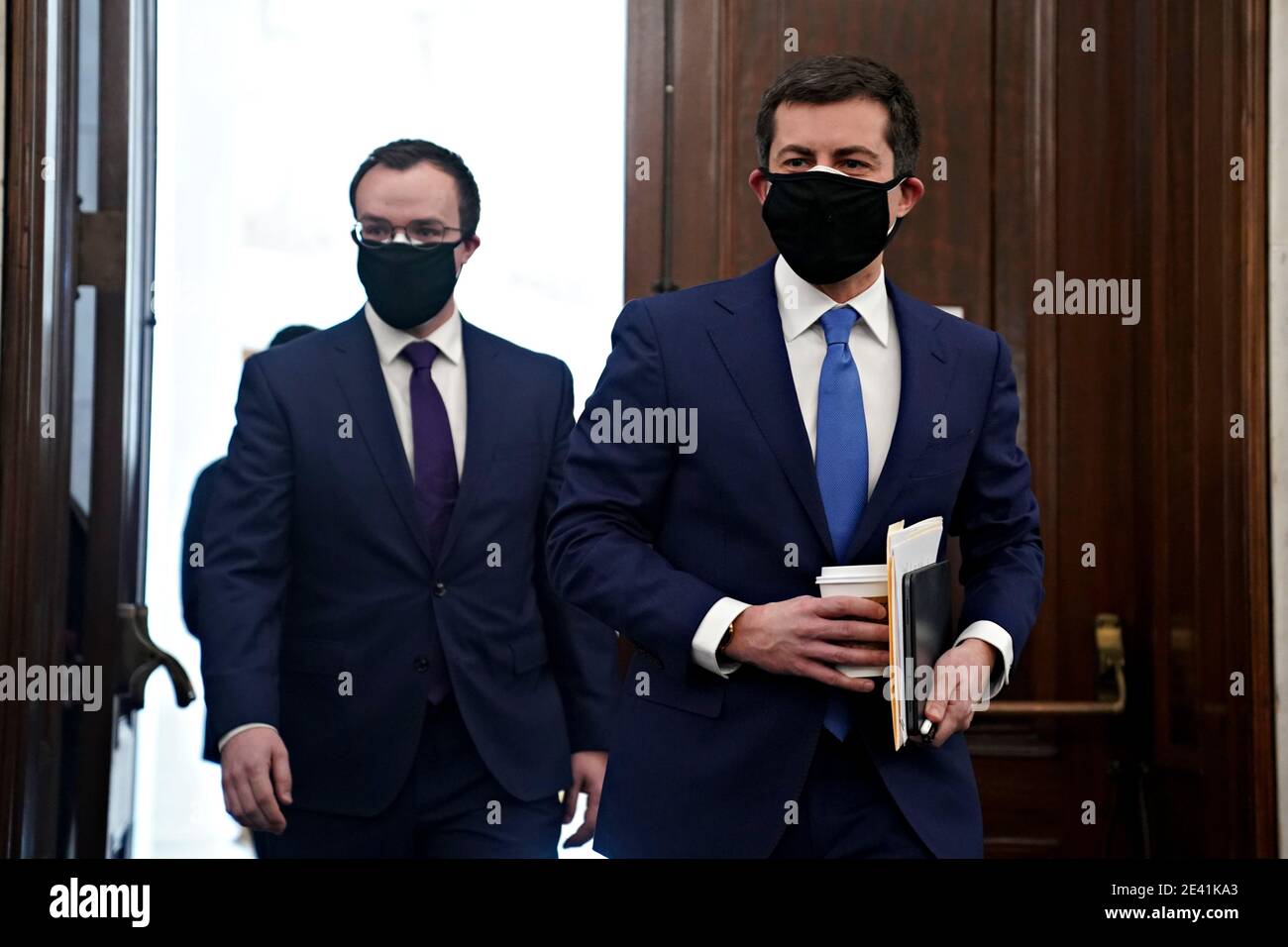 Pete Buttigieg, U.S. secretary of transportation nominee for U.S. President Joe Biden, right, wears a protective mask while arriving to a Senate Commerce, Science and Transportation Committee confirmation hearing in Washington, DC, U.S., on Thursday, Jan. 21, 2021. Buttigieg, is pledging to carry out the administration's ambitious agenda to rebuild the nation's infrastructure, calling it a 'generational opportunity' to create new jobs, fight economic inequality and stem climate change. Credit: Stefani Reynolds/Pool via CNP | usage worldwide Stock Photo