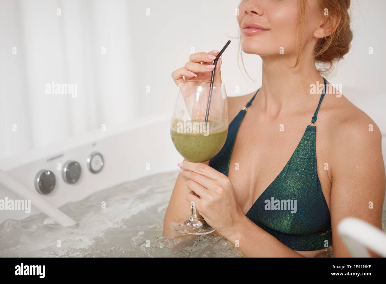 Cropped shot of a happy healthy woman having detox smoothie at spa salon,  relaxing in whirlpool bath, copy space. Woman in a bikini getting  hydromassa Stock Photo - Alamy