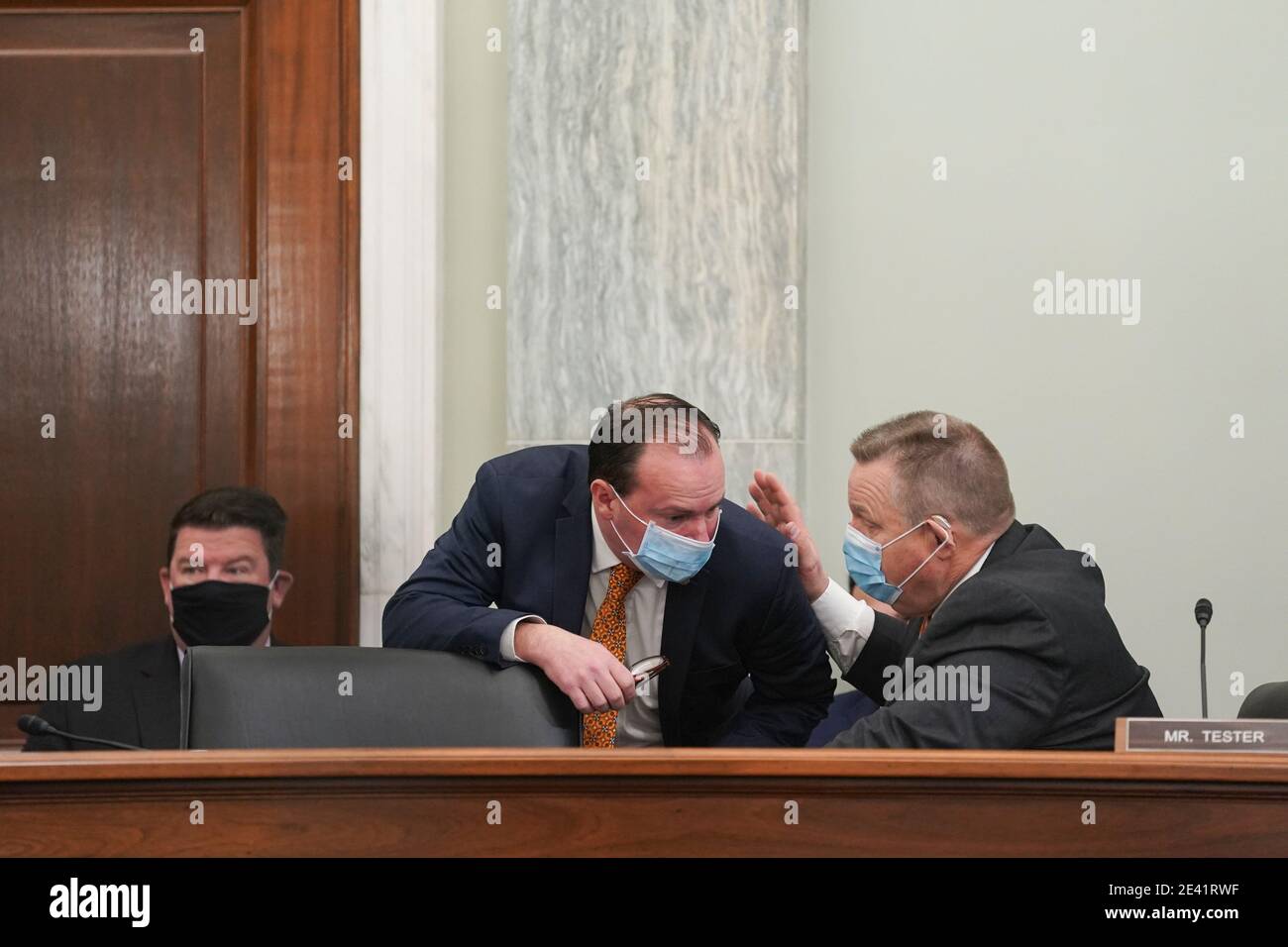 United States Senator Jon Tester (Democrat of Montana), right, and US Senator Mike Lee (Republican of Utah), wear protective masks while talking during a Senate Commerce, Science and Transportation Committee confirmation hearing for U.S. Secretary of Transportation nominee Pete Buttigieg in Washington, DC, U.S., on Thursday, Jan. 21, 2021. Buttigieg, is pledging to carry out the administration's ambitious agenda to rebuild the nation's infrastructure, calling it a 'generational opportunity' to create new jobs, fight economic inequality and stem climate change. Credit: Stefani Reynolds/Pool Stock Photo