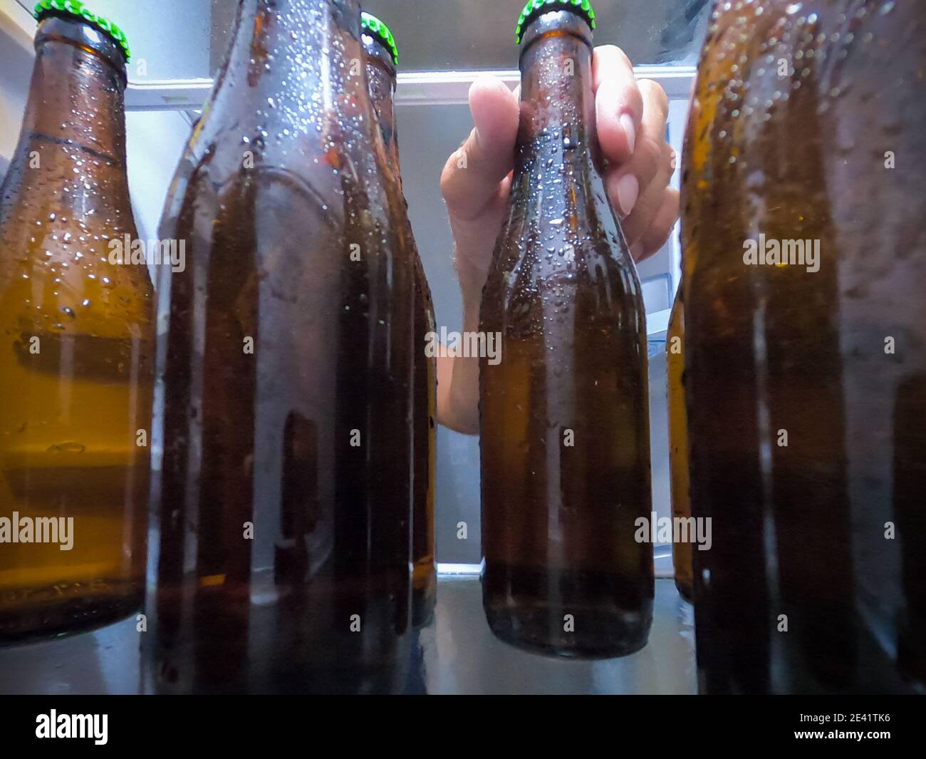 https://c8.alamy.com/comp/2E41TK6/a-hand-picking-up-an-ice-cold-beer-bottle-from-the-fridge-beer-concept-2E41TK6.jpg