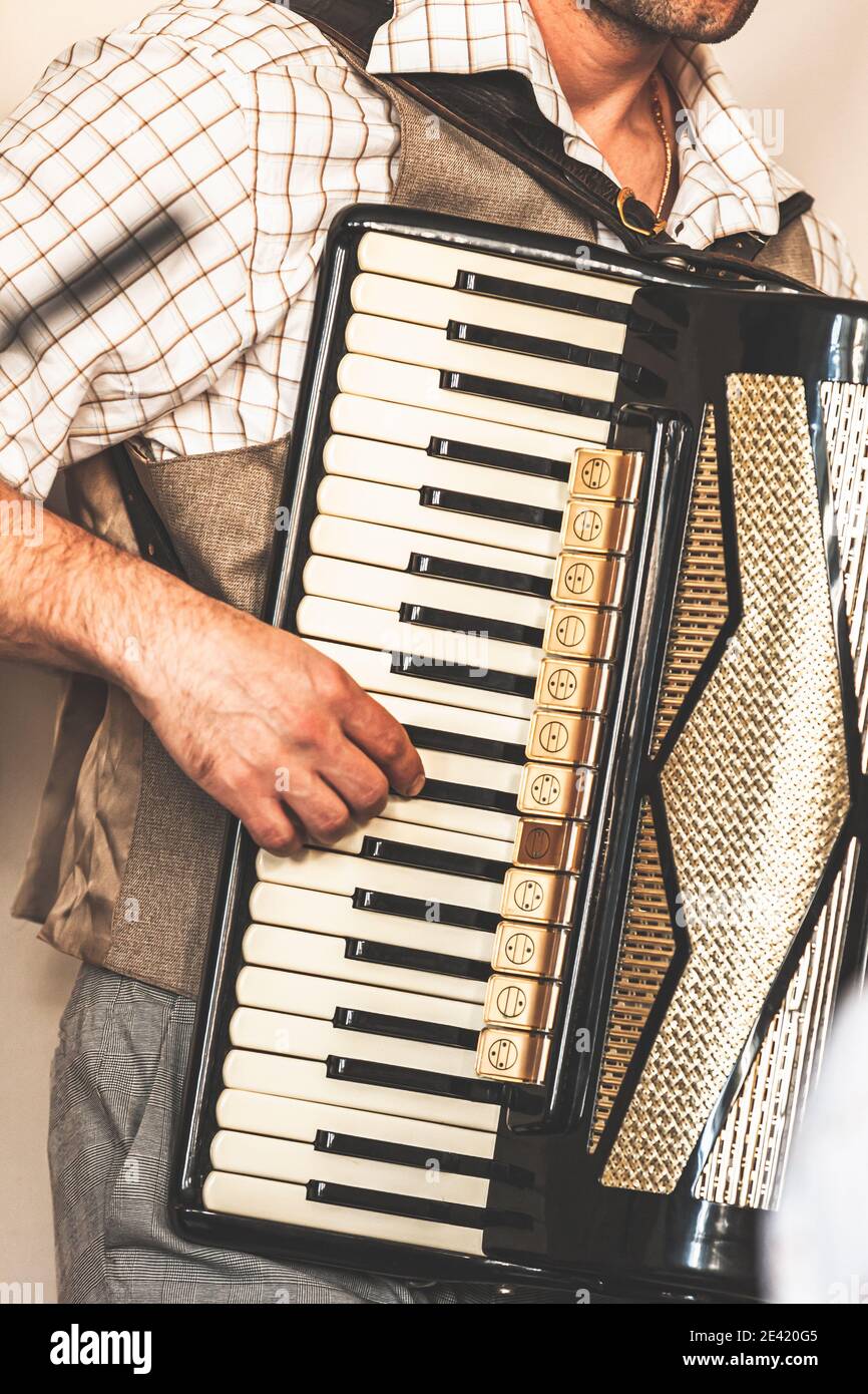 Accordionist plays accordion. Close-up vertical photo with soft selective focus Stock Photo