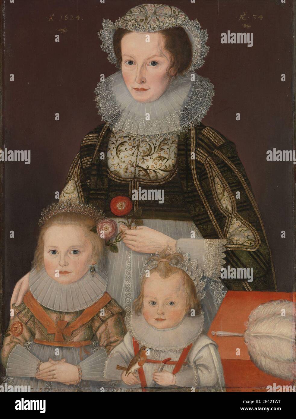 unknown artist, seventeenth century, A Lady and Her Two Children, 1624. Oil on panel.   background , bird , black , children , collars , coral , costume , crown , earrings , European Robin , family , feather , flowers (plants) , gold , headdress , Jacobean , lace , orange , pink (color) , portrait , red , toys (recreational artifacts) , Tudor , white (color) , woman Stock Photo