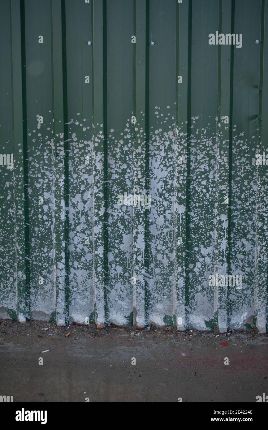 Vertical shot of a metal gate with white paint sprayed on its surface Stock Photo