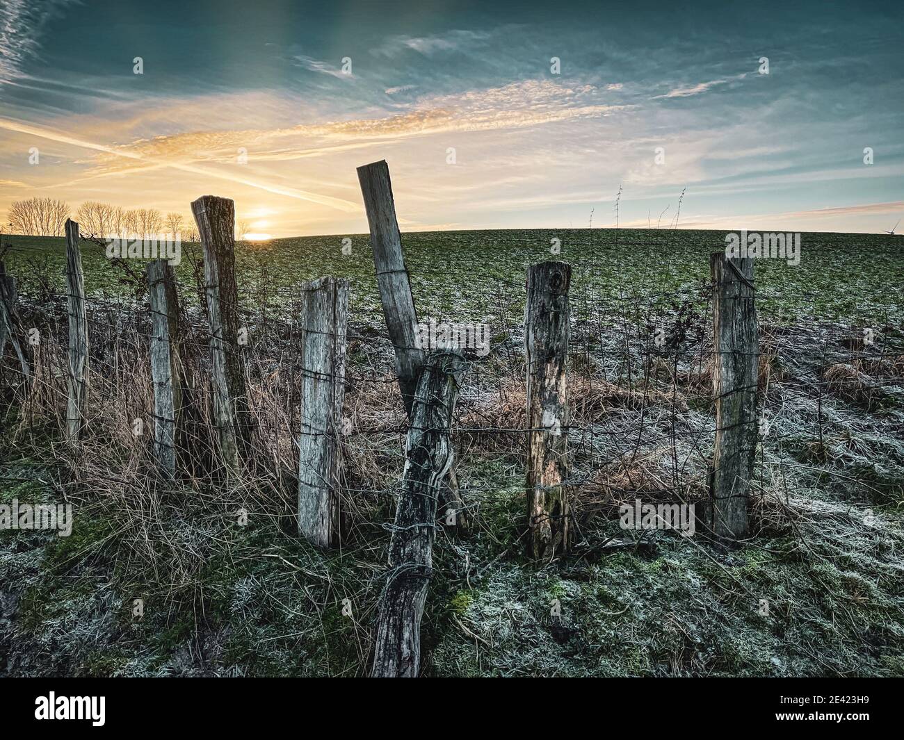 an old pasture fence borders a field and the sky is blue Stock Photo ...