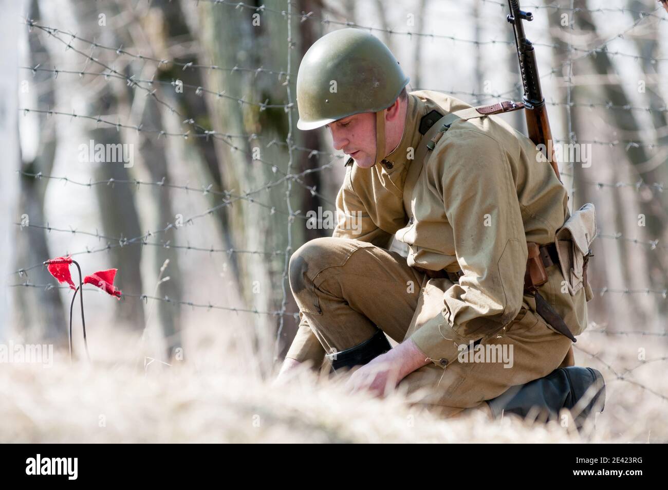 KALININGRAD, RUSSIA - April 08, 2018: Unidentified man in the uniform of a Soviet soldier sets up a land mine Stock Photo