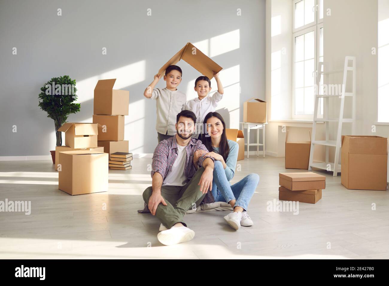 Portrait of smiling mother, father and children in their new house on ...