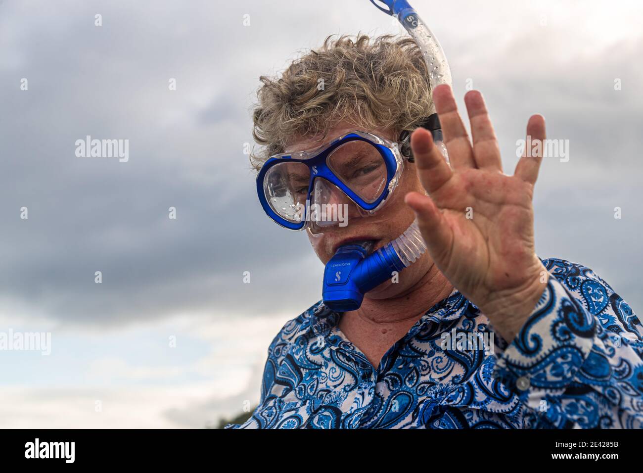 Dressed woman greets with snorkel and diving mask, Deboyne Islands, Papua New Guinea Stock Photo