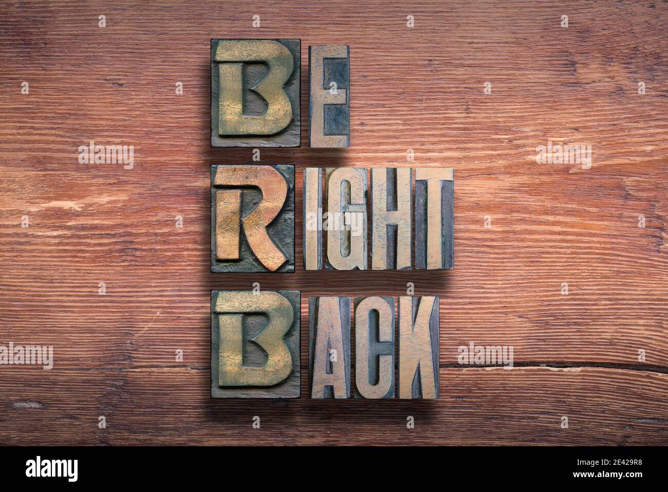 be right back abbreviation combined on vintage varnished wooden surface Stock Photo