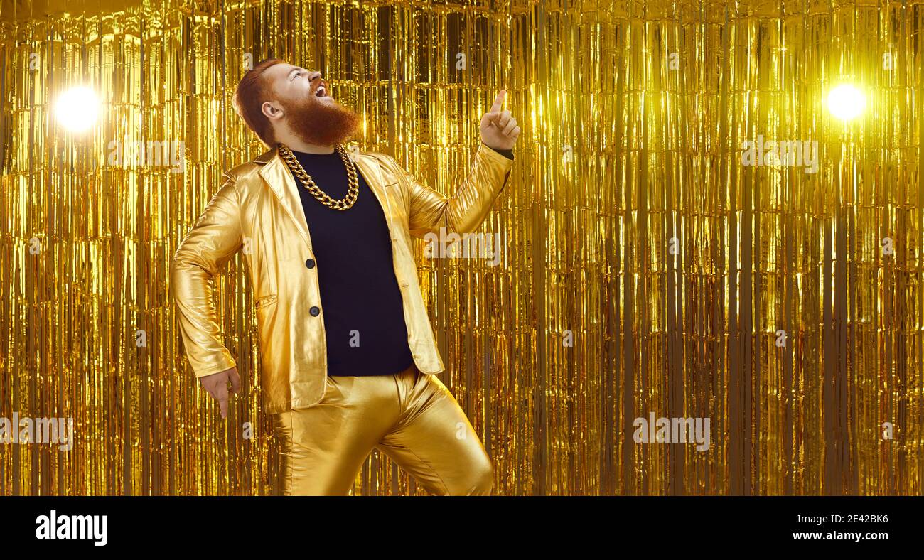Funny uninhibited man in a shiny golden suit singing songs and having fun at a party Stock Photo
