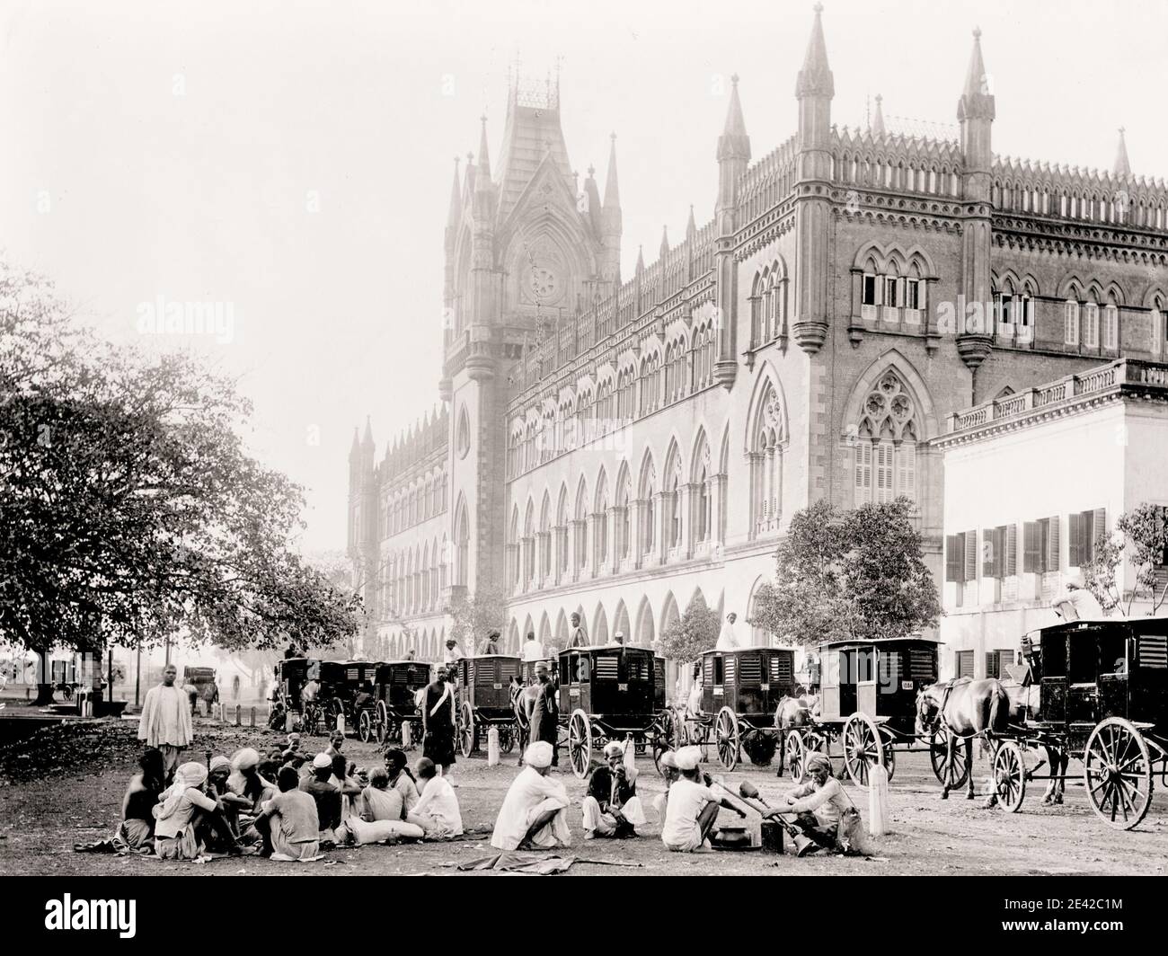 Vintage 19th century photograph: street scene India, people seated and hackney carriages. Stock Photo