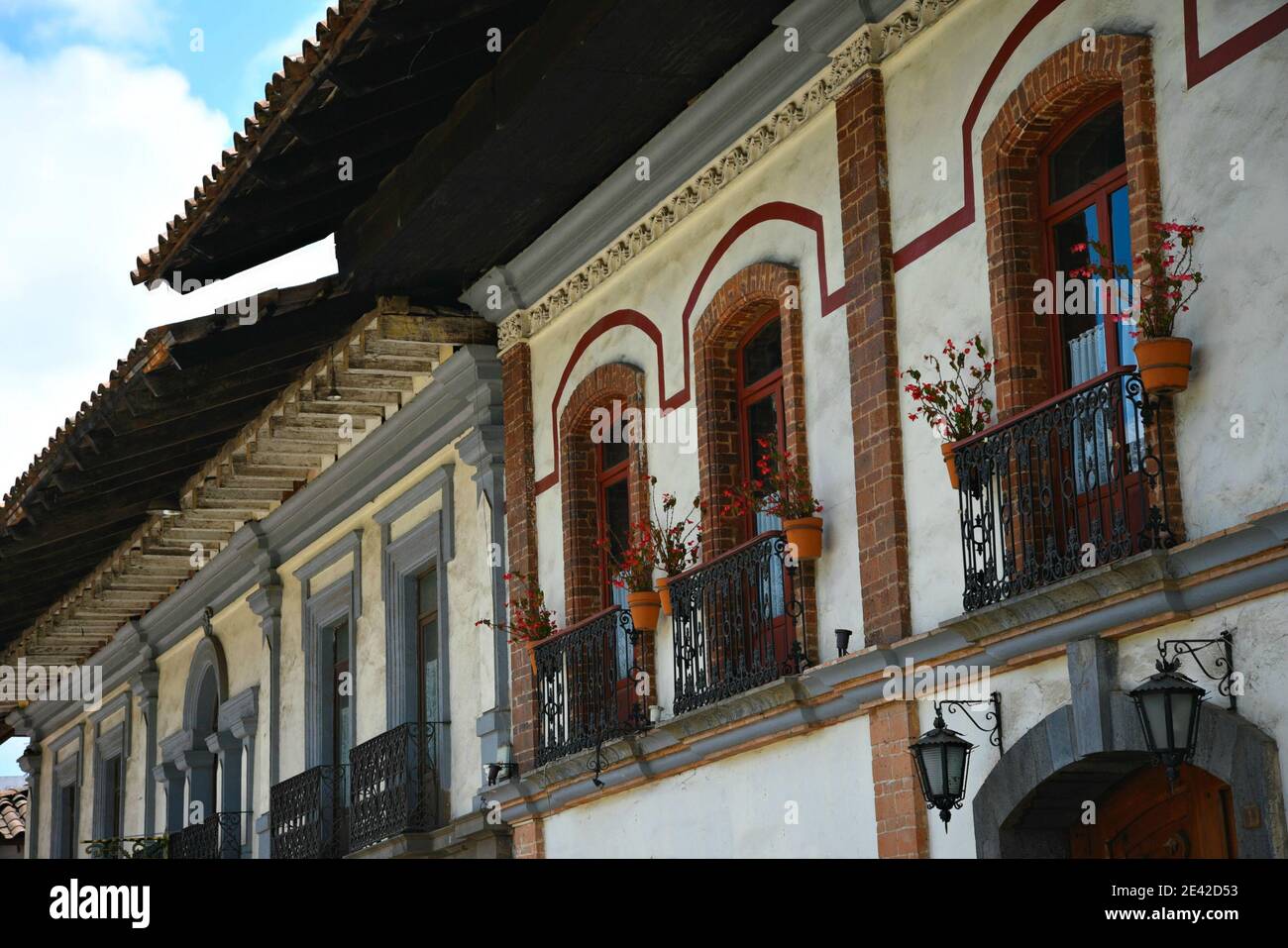Colonial house facade with brick windows on a white washed stucco wall with  handcrafted iron balcony railings in Zacatlán de las Manzanas, Mexico Stock  Photo - Alamy, image size:1300x957