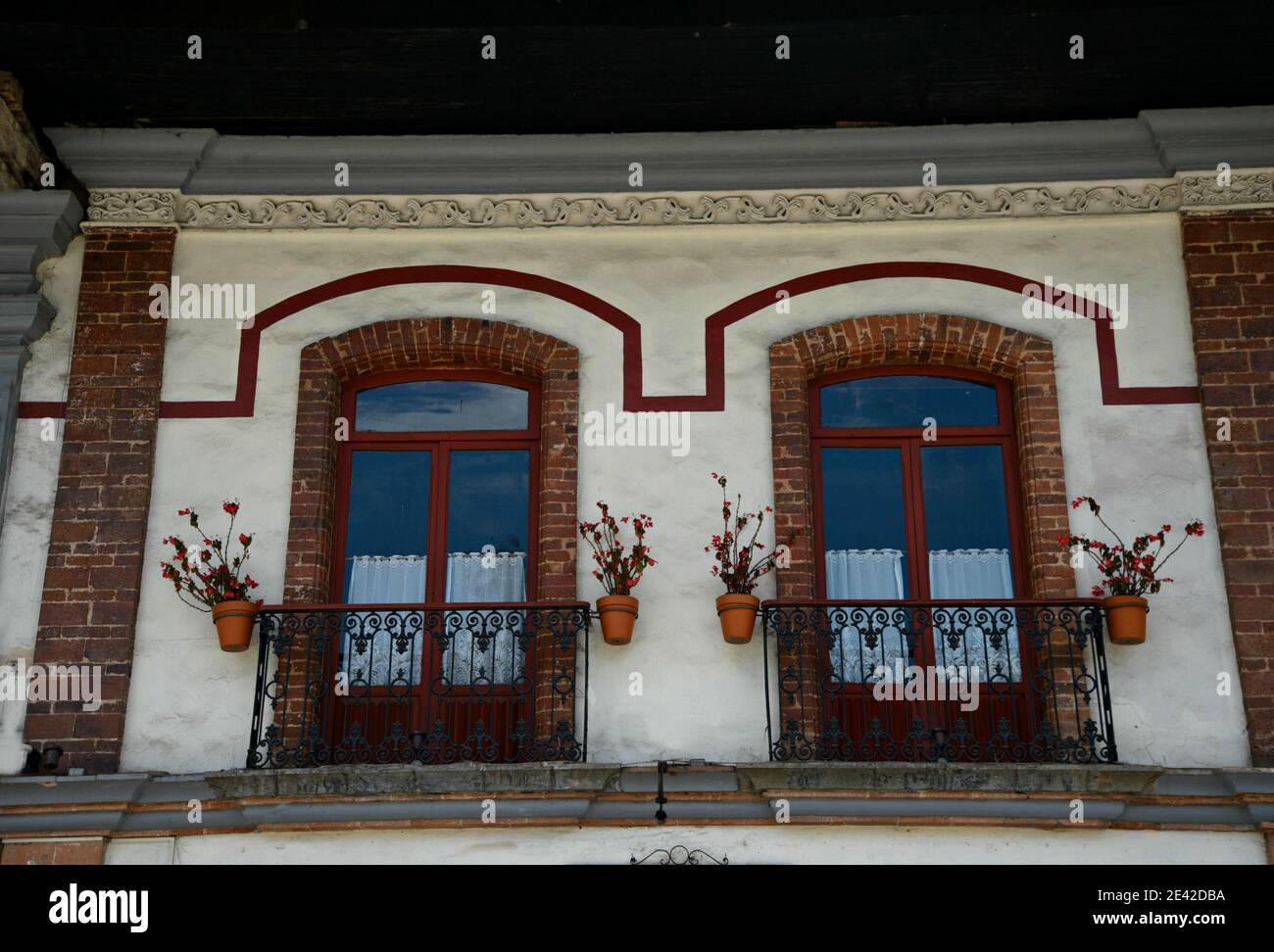 Colonial house facade with brick windows on a white washed stucco wall with  handcrafted iron balcony railings in Zacatlán de las Manzanas, Mexico Stock  Photo - Alamy, image size:1300x972