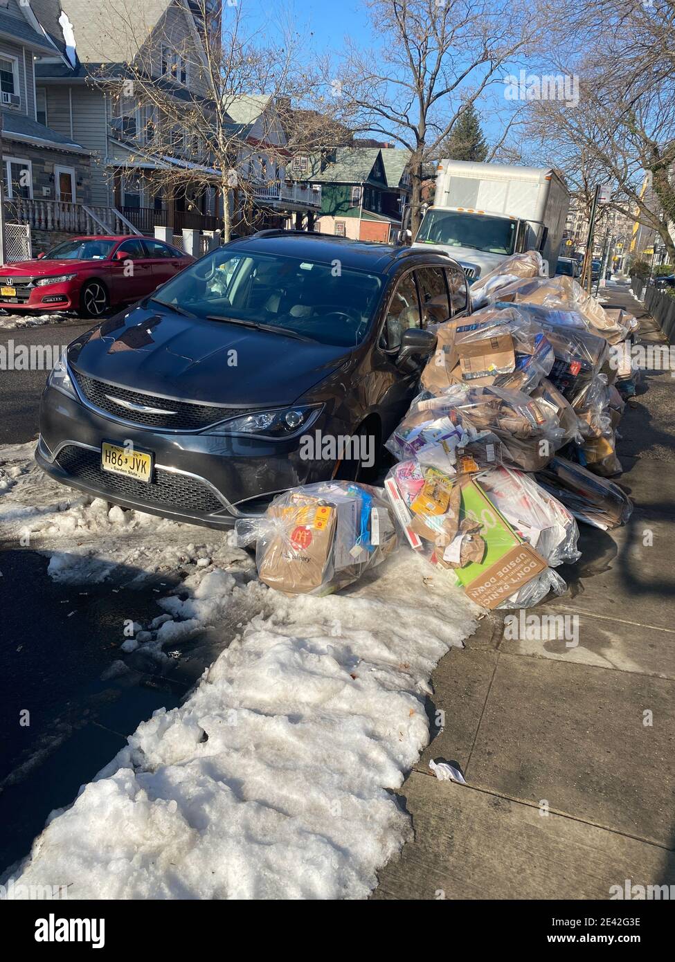 Snow and parked cars makes garbage pickup difficult in New York City where there are no alleys so garbage has to be put out on the street  which makes Stock Photo