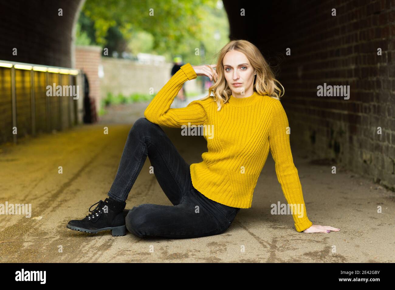 a portrait of a young woman sitting on the floor Stock Photo - Alamy