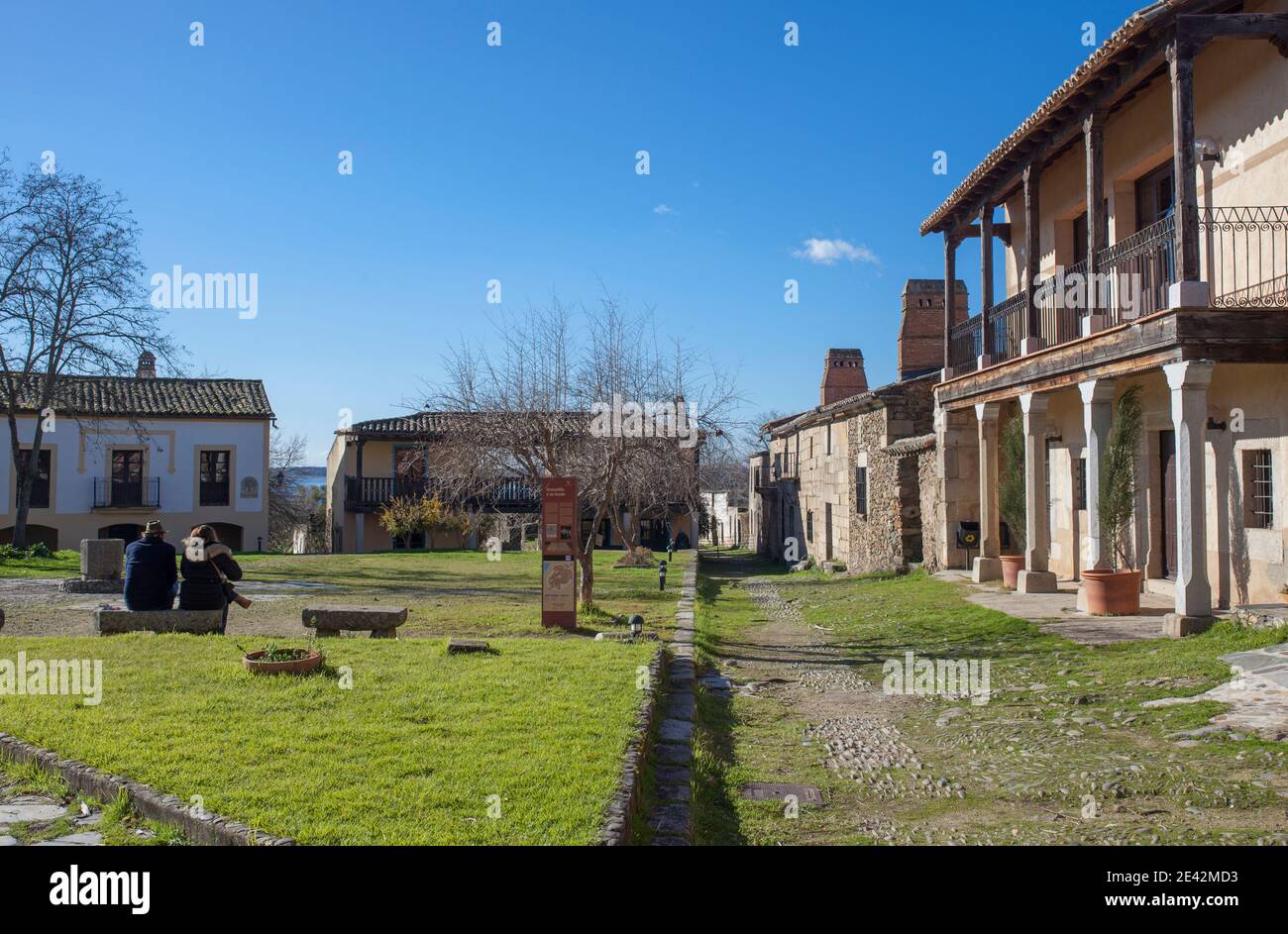 Visitors sitting at Granadilla village main square. Medieval town evacuated in 1965, know being rehabilitated. Extremadura, Spain Stock Photo