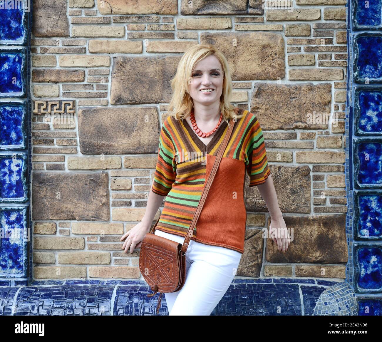 A woman with mid XX-century hairstyle and clothes poses outdoors Stock Photo