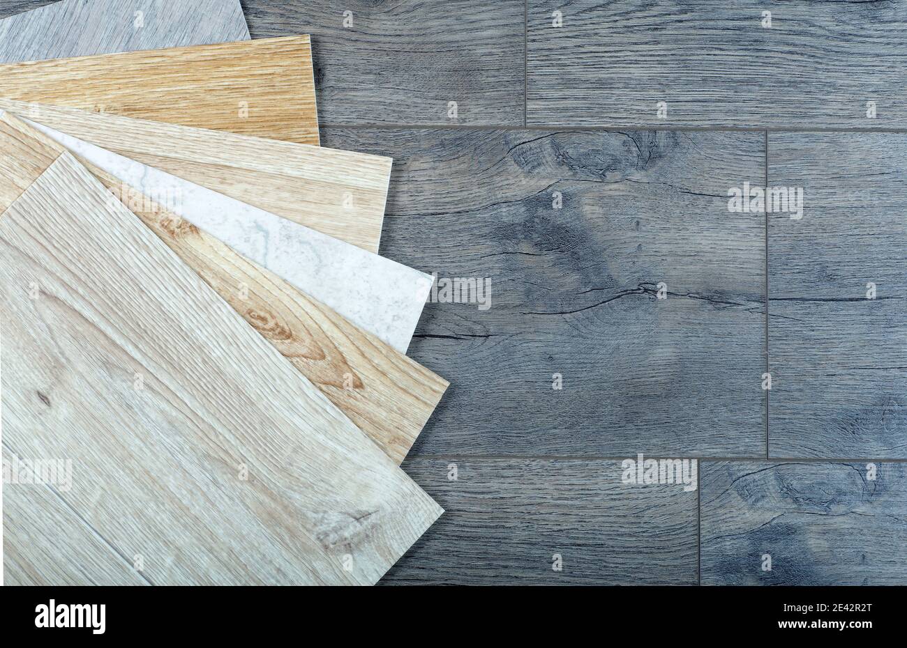Vinyl and linoleum samples on a wooden background. Vinyl for flooring with wood grain texture and pattern. Stock Photo