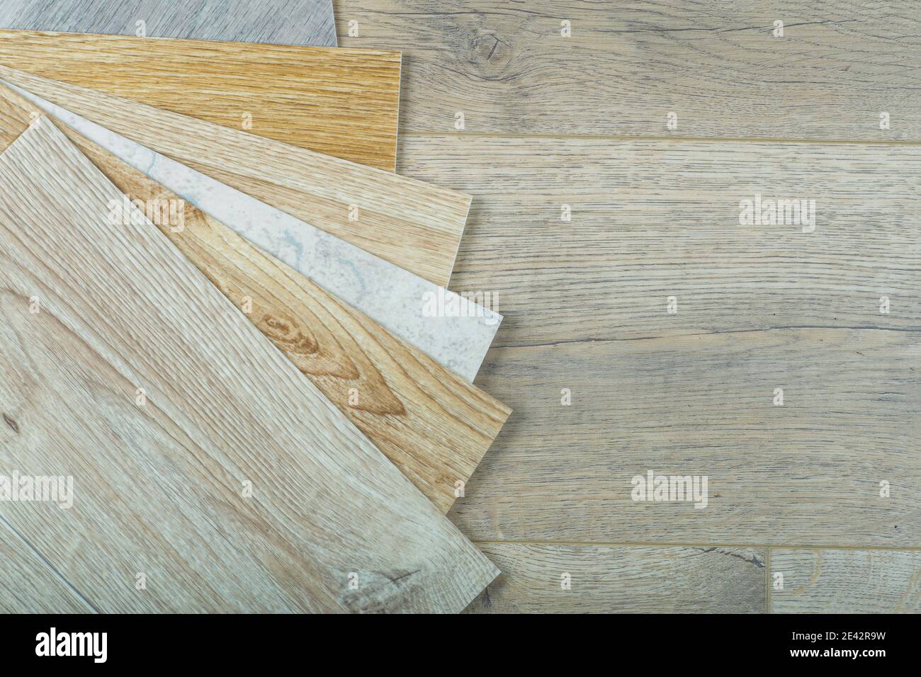 Vinyl and linoleum samples on a wooden background. Vinyl for flooring with wood grain texture and pattern. Stock Photo