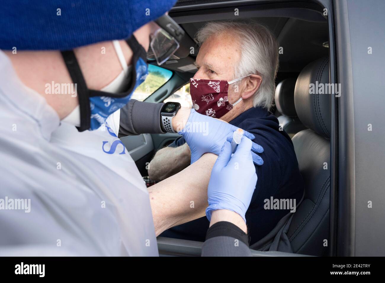 Round Rock, USA. 21st Jan, 2021: South University nursing student Zach Beyer administers the COVID-19 vaccine to Ed McMenemy at a drive-through clinic. More than 2,000 doses were given in people's arms at the clinic on the previous day as Texas ramps up its vaccine response. Credit: Bob Daemmrich/Alamy Live News Stock Photo