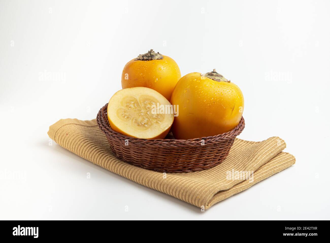 Isolated shot of a woven basket with Cocona tropical fruits (Solanum sessiliflorum) Stock Photo