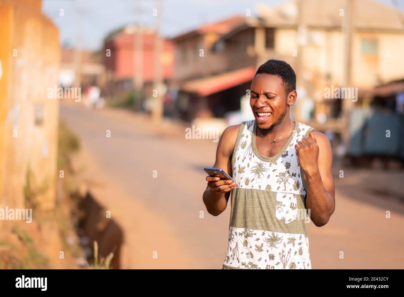 young black man using his phone rejoices Stock Photo