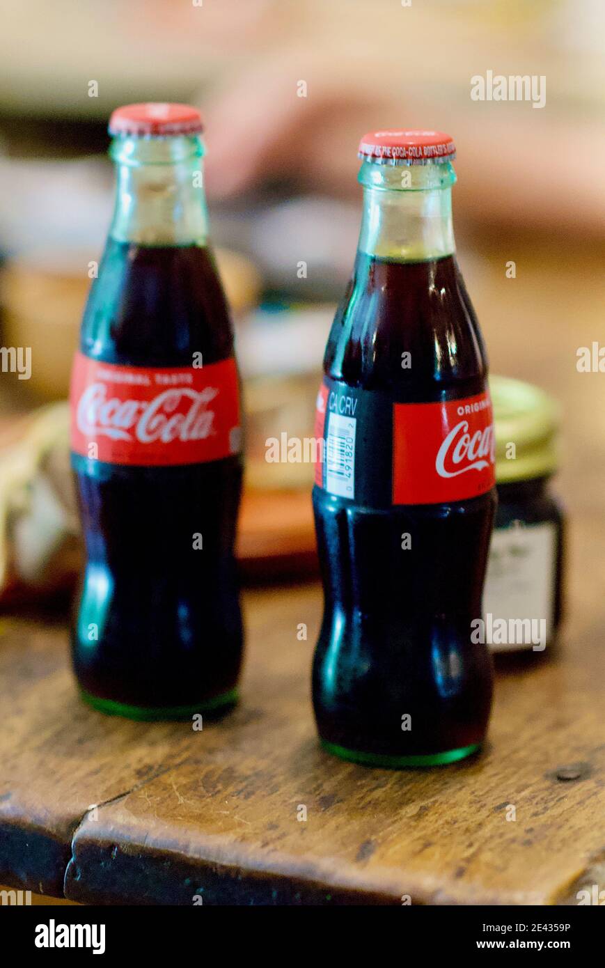 Mayberry, Virginia / USA - July 5, 2020: Two glass bottles of ice cold Coca-Cola on a worn wooden table at the historic Mayberry Trading Post. Stock Photo