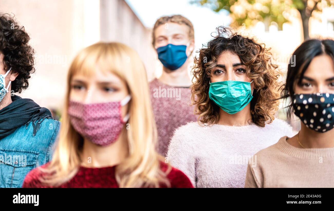 Urban crowd of citizens walking on city street covered by face mask - New normal society concept with young people on worried anxiety mood Stock Photo