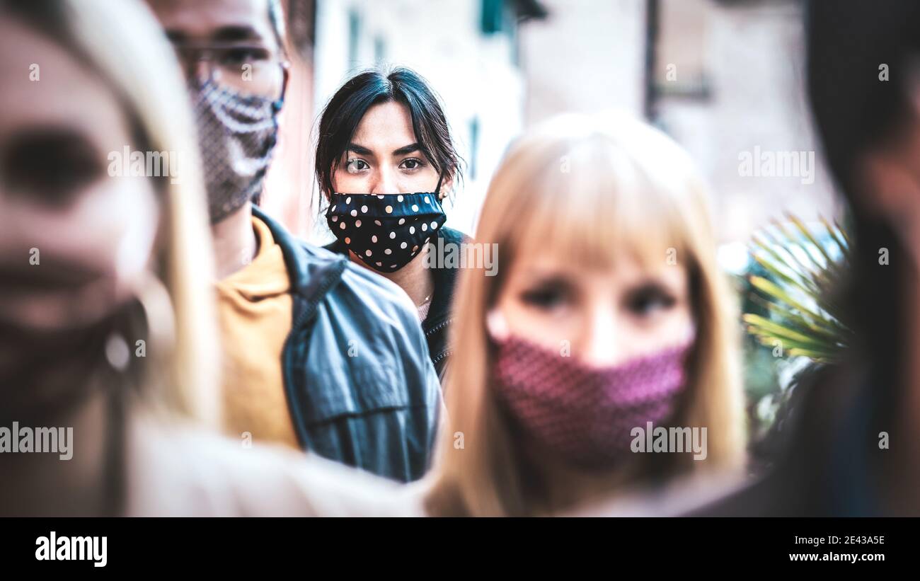 Urban commuter crowd of people moving on city street covered by face mask - New normal human condition and society concept - Focus on middle woman Stock Photo